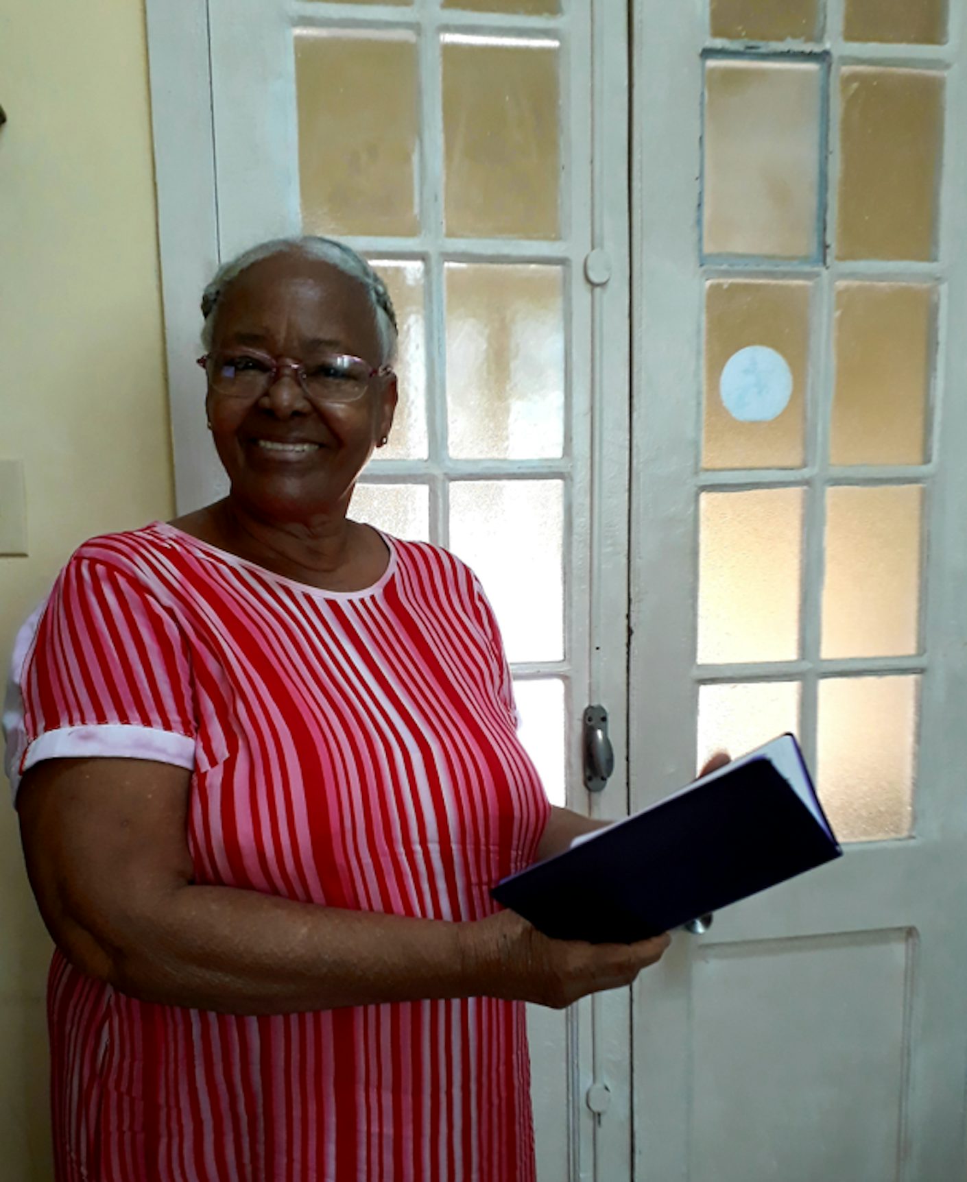 Remiga (76 år) med den nye Bibelen hun fikk på Bibelselskapets Cuba-kontor.