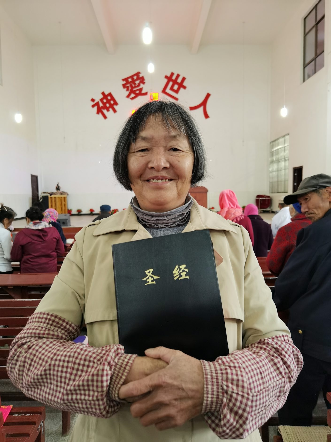 Cuihua, en eldre kvinne, viser fram Bibelselskapets storskriftbibel i en kinesisk kirke.