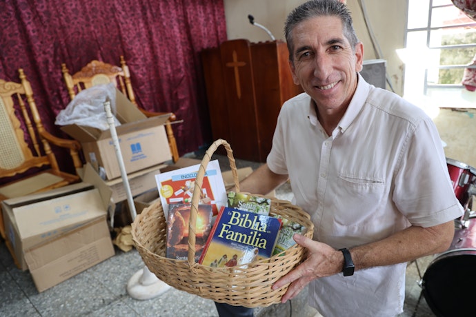 Alain Montano viser fram innholdet i en av bibelkurvene.