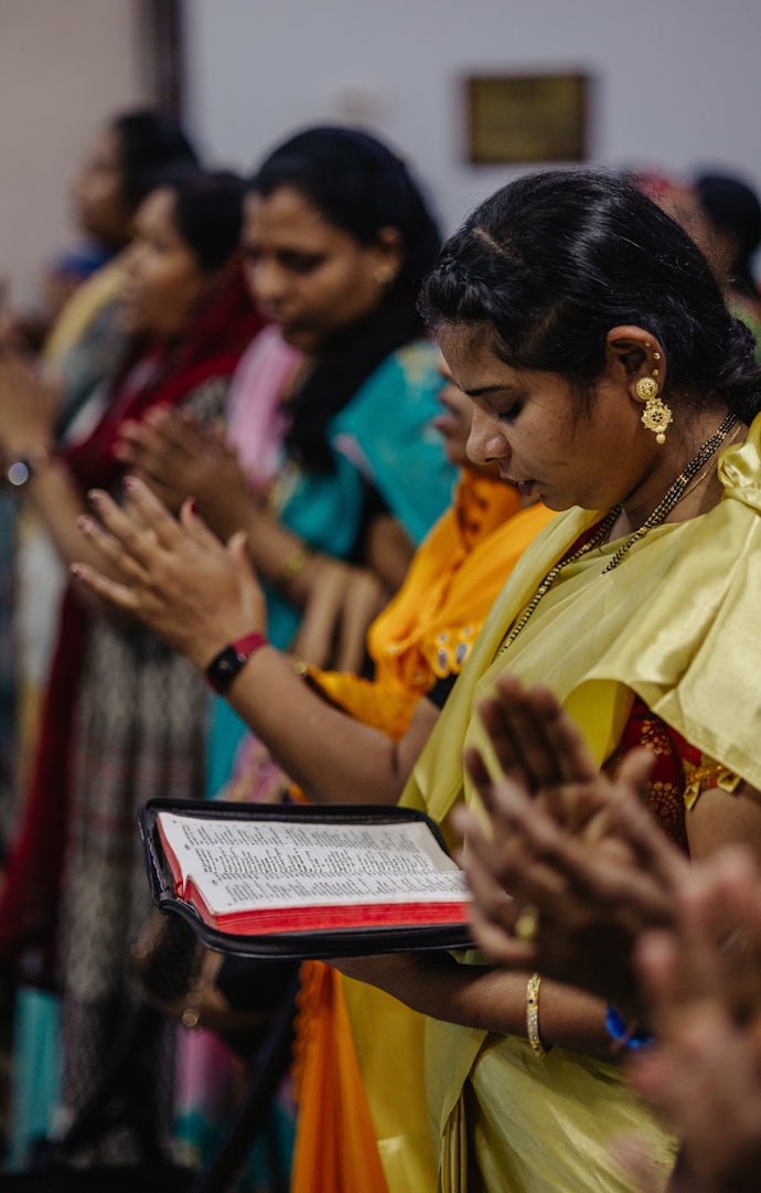 Noen hushjelper, «maids», avbildet i bønn i en migrantkirke.