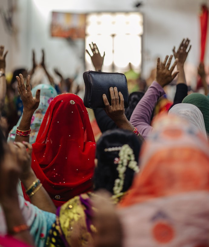 Kvinner i en migrantmenighet i Kuwait. Her avbildet bakfra - løfter hendene under lovsang.