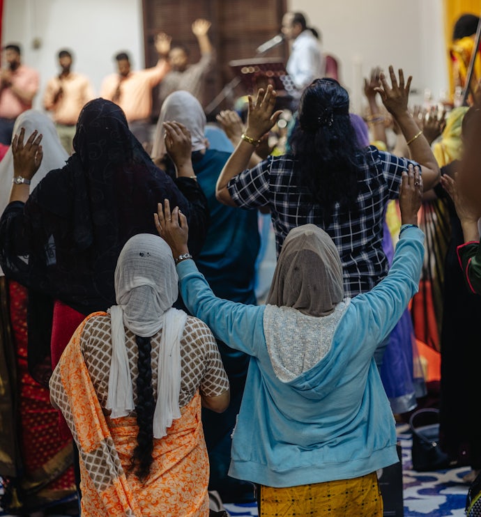 Kvinner i bønn i en migrantkirke.