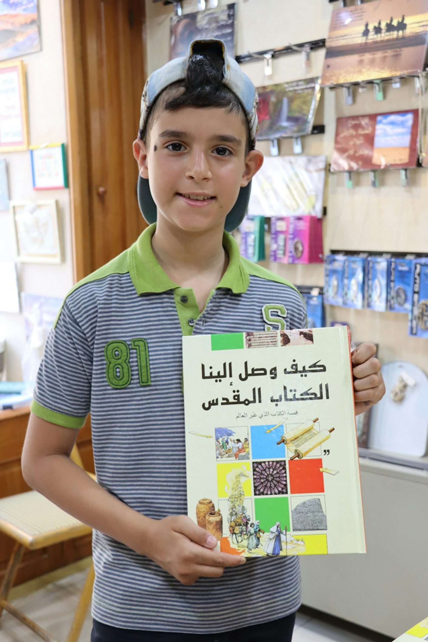 Illustrasjonsfoto: Gutt viser fram en bok i Bibelselskapets butikk i Syria.