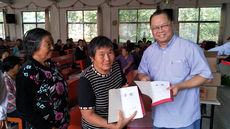 Saman med to lokale medarbeidarar syner Daniel Loh (til høgre) fram nye biblar i ei kinesisk kyrkje.