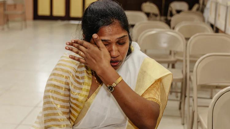 Sunitha, en ung indisk kvinne, tørker vekk en tåre