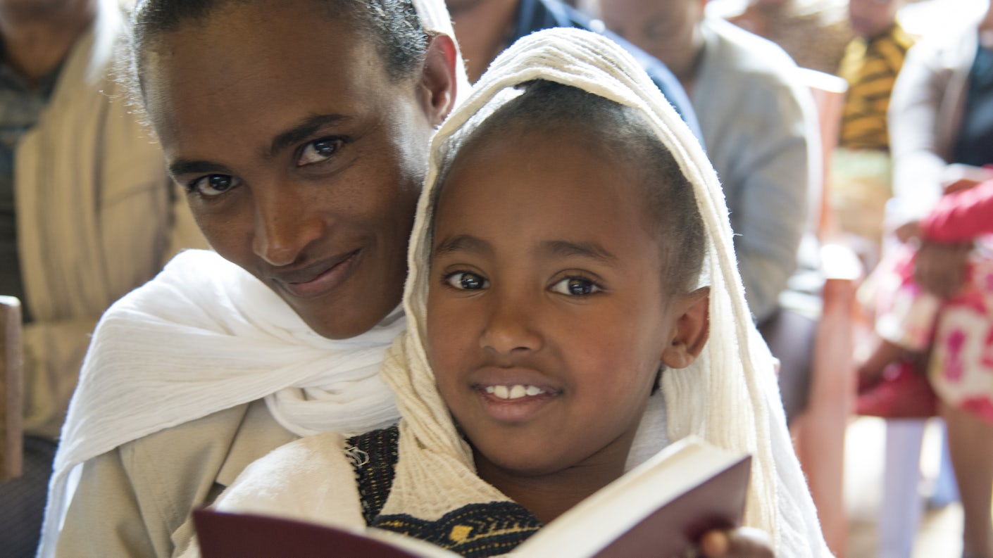 Dame med barn på fanget leser i bibelen