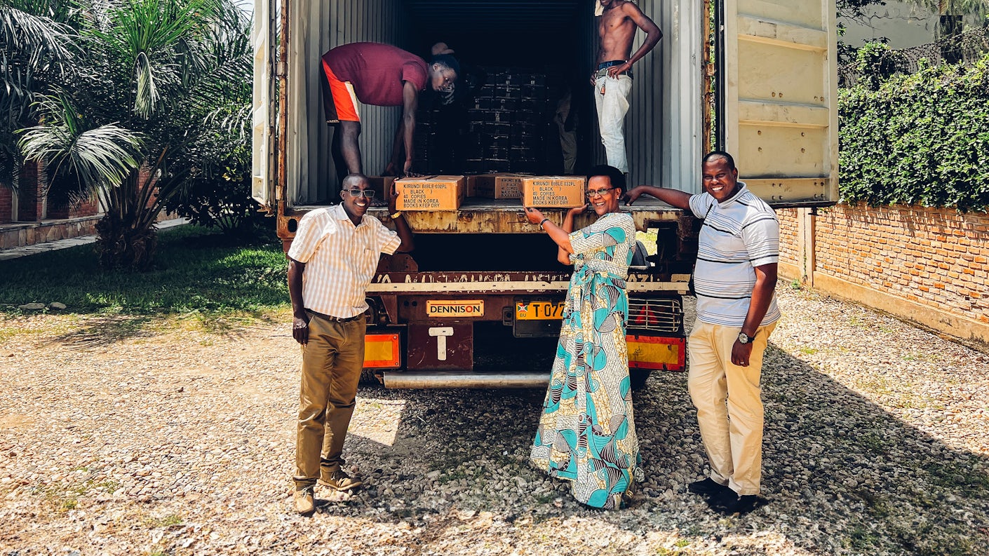 Marjorie Niyungeko foran en lastebil med bibler sammen med sine kollegaer.