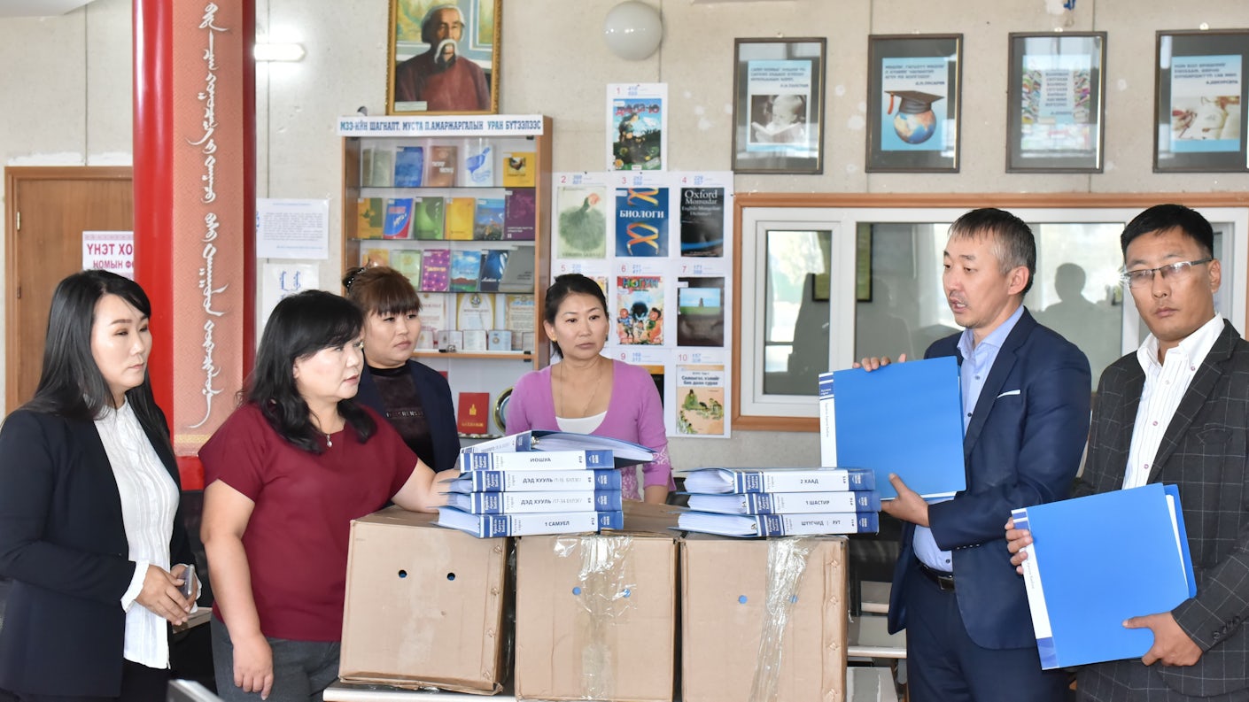 Seks personer, deriblant representanter fra Bibelselskapet overrekker en fullstendig utgave av blindeskriftsbibelen til hovedbiblioteket i byen Darkhan, Mongolia.