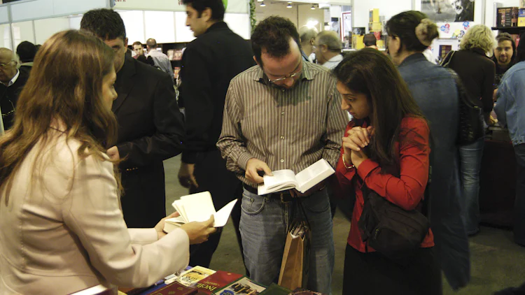 En kvinne og en mann på en bokmesse blar i en bibel