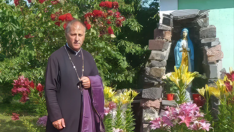 Fader Stepan Podolsjak avbildet utendørs i preste-ornat ved et helgenbilde