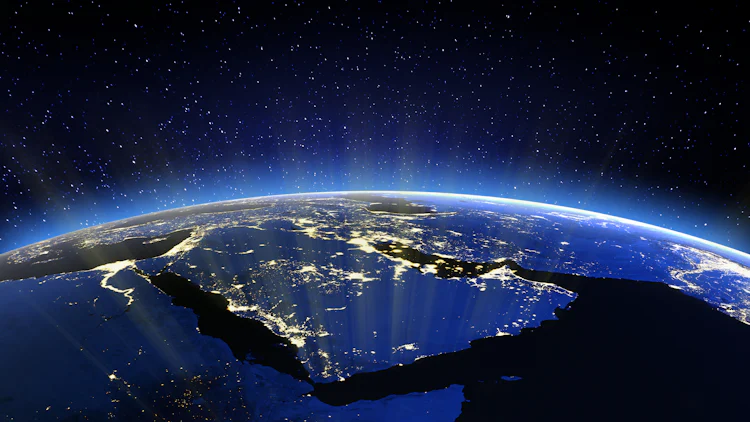 Foto/illustrasjon sett fra verdensrommet der jordkrumningen kommer fram - og lys skinner fra befolkede områder i landene omkring Den persiske gulf.