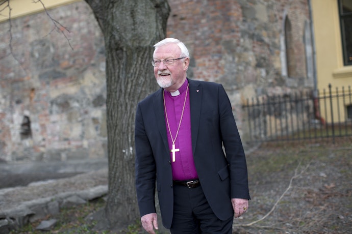Biskop Ole Christian Kvarme utenfor en steinkirke.